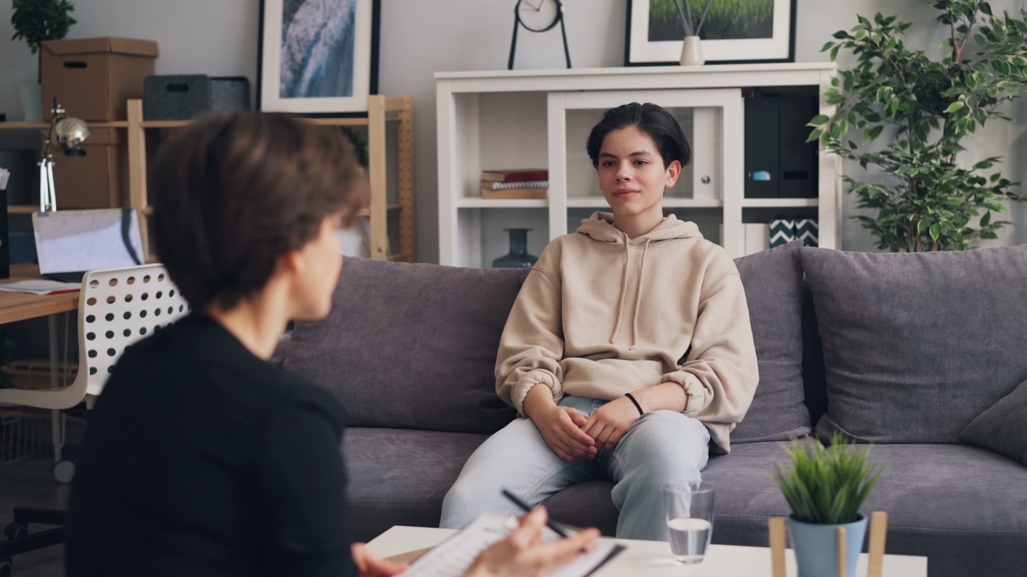 Foto de um adolescente conversando com seu terapeuta.